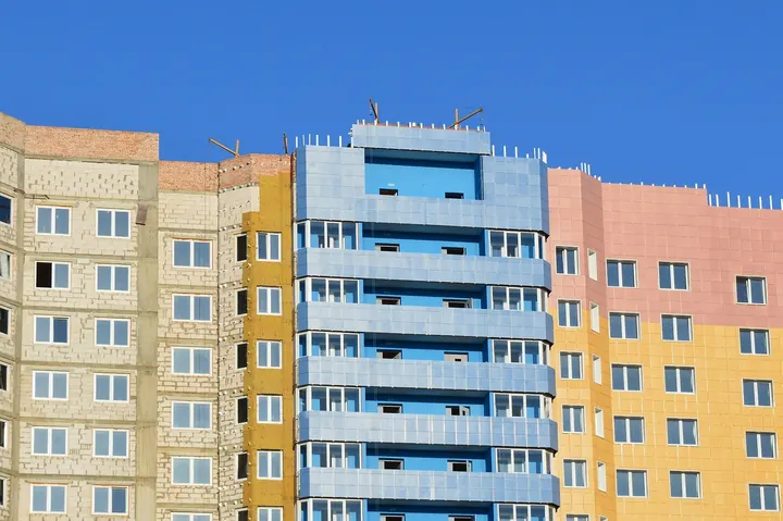 Fachada en construcción con aislamiento visible y revestimiento exterior